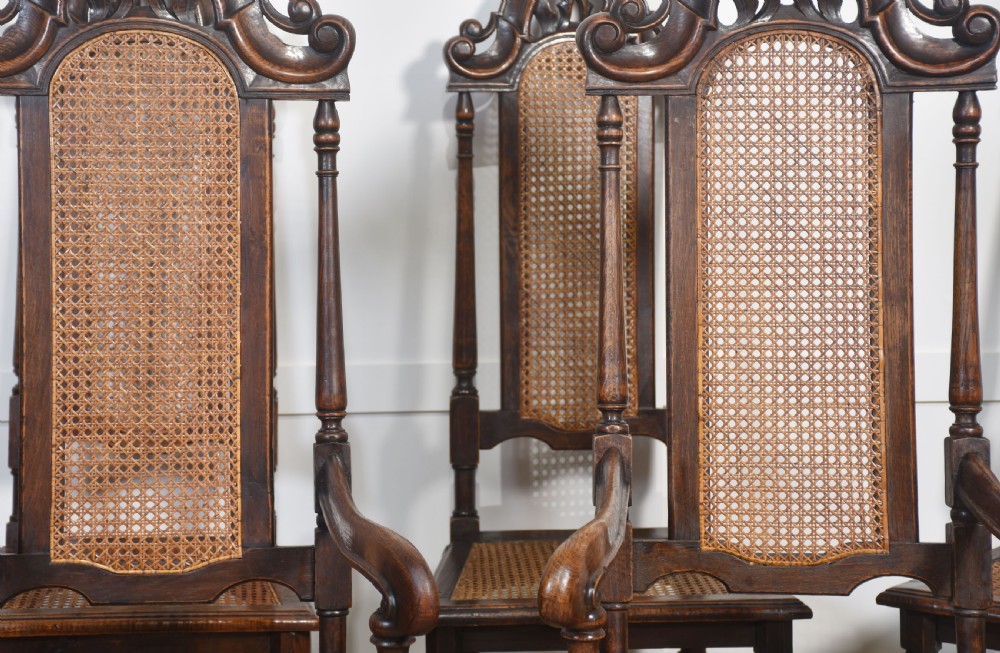 Set of eight carved dark oak high-back dining chairs with woven cane backrests and seats, comprising two armchairs and six side chairs. View III