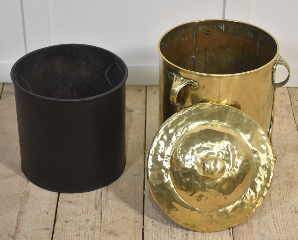 A cylindrical polished brass Art Nouveau coal bin featuring stylised cast feet, side handles, and a domed lid with a finial handle. View V