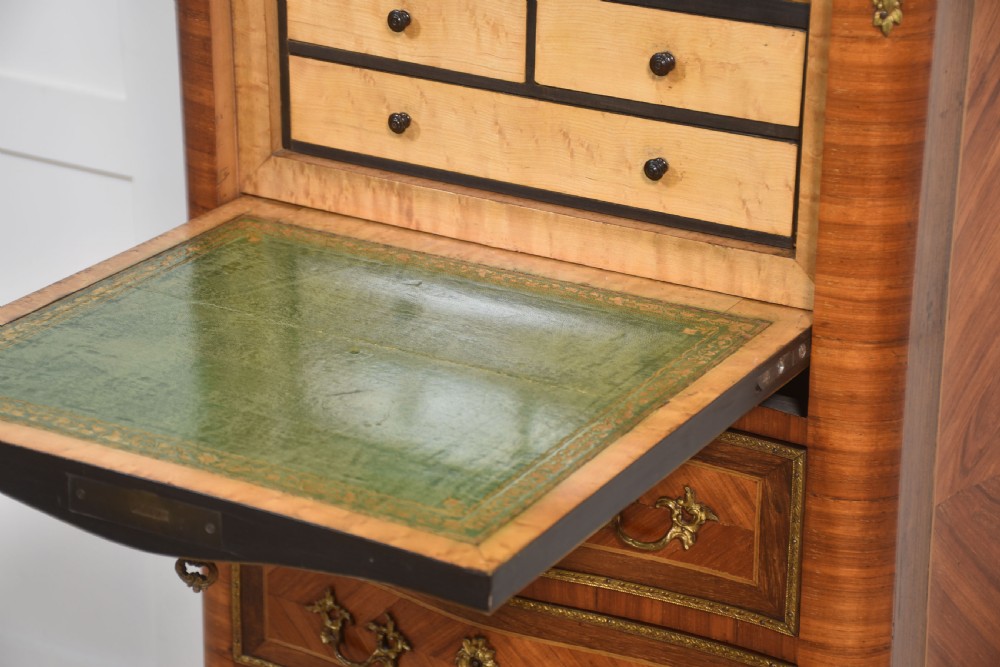 A tall, narrow French kingwood secretaire abattant featuring herringbone parquetry inlay, brass ormolu mounts, and seven drawer fronts with decorative handles. View V