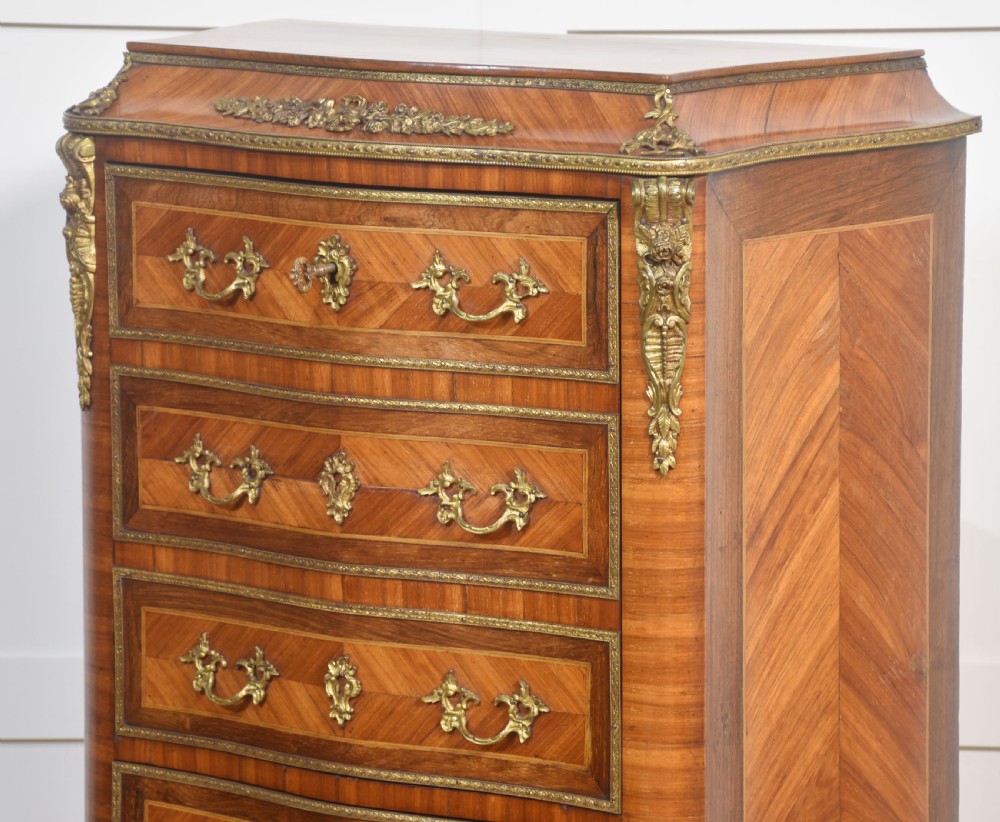 A tall, narrow French kingwood secretaire abattant featuring herringbone parquetry inlay, brass ormolu mounts, and seven drawer fronts with decorative handles. View VII