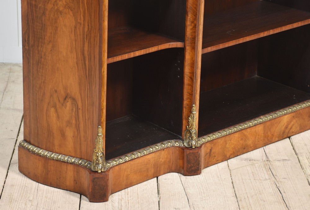 An antique figured walnut breakfront open bookcase featuring three shelf compartments and ornamental gilt metal mounts along the frieze and pilasters. View III