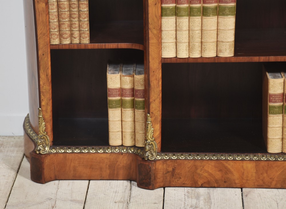 An antique figured walnut breakfront open bookcase featuring three shelf compartments and ornamental gilt metal mounts along the frieze and pilasters. View XIII