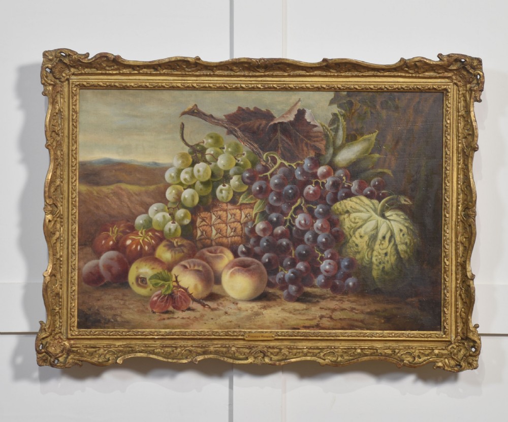 An antique oil on canvas still life painting depicting an arrangement of grapes, peaches, and melons within an ornate gilded frame.