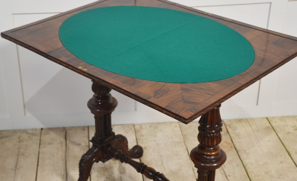 A 19th-century rosewood fold-over card table featuring turned legs, carved pedestals, and a stretcher base. View III