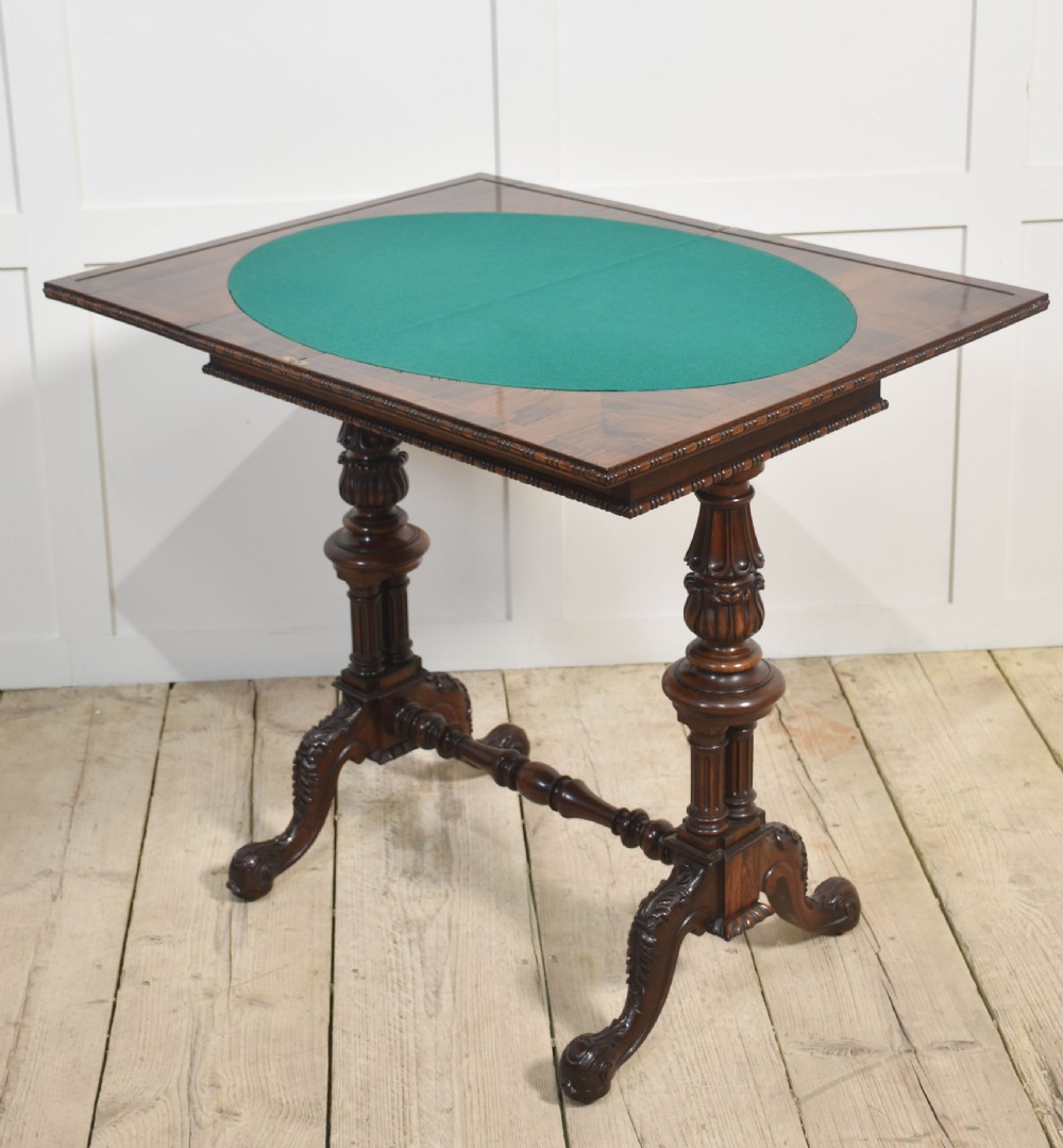 A 19th-century rosewood fold-over card table featuring turned legs, carved pedestals, and a stretcher base. View VII