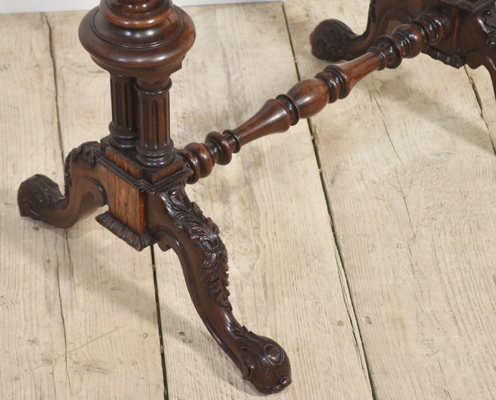 A 19th-century rosewood fold-over card table featuring turned legs, carved pedestals, and a stretcher base. View X