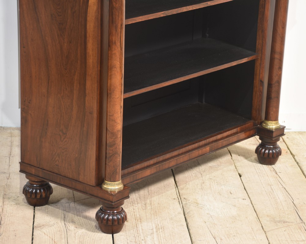 A 19th-century rosewood open bookcase featuring brass pillar supports, a tiered upper shelf gallery, open lower shelves, and turned feet. View IX