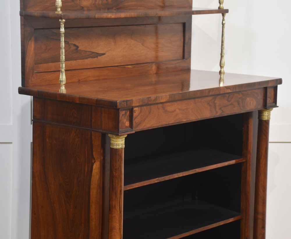 A 19th-century rosewood open bookcase featuring brass pillar supports, a tiered upper shelf gallery, open lower shelves, and turned feet. View X