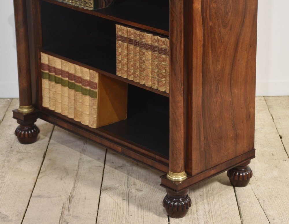 A 19th-century rosewood open bookcase featuring brass pillar supports, a tiered upper shelf gallery, open lower shelves, and turned feet. View XV
