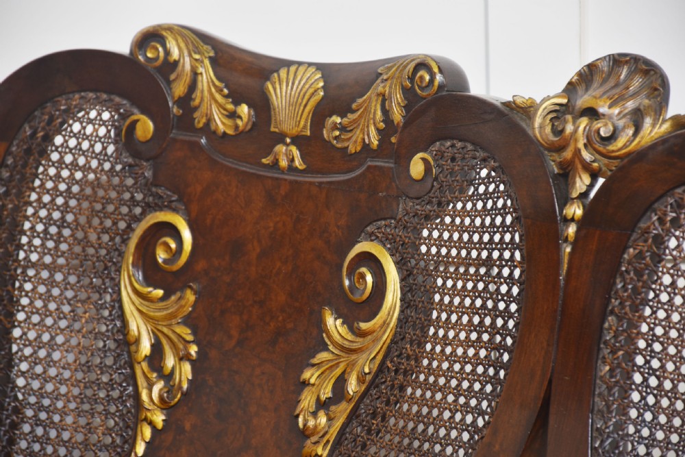 A three-seater carved walnut sofa featuring caned panels, parcel-gilt shell carved details, cabriole legs, and three rose-pink velvet seat cushions. View III