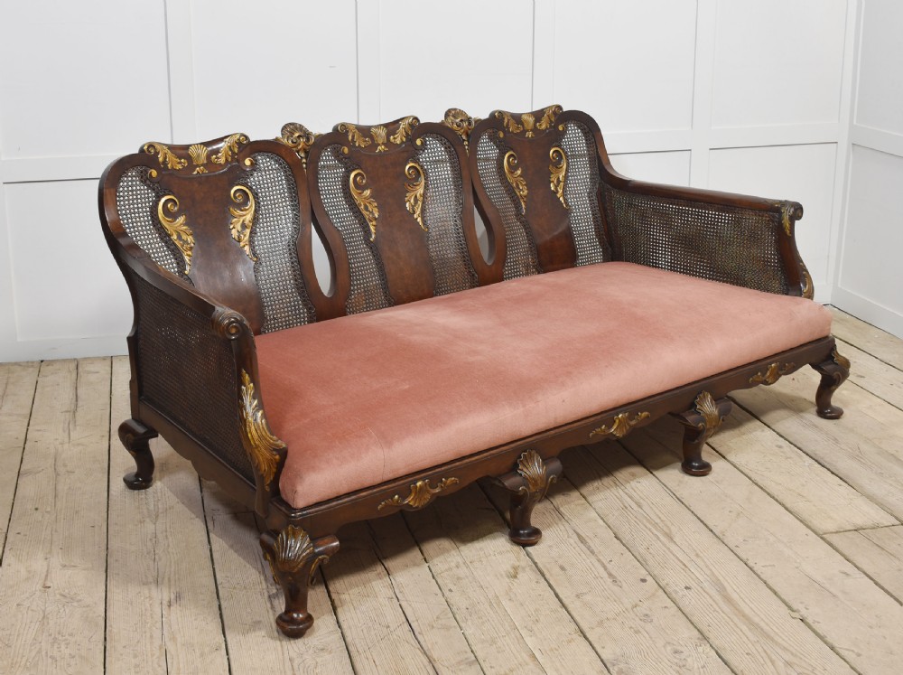 A three-seater carved walnut sofa featuring caned panels, parcel-gilt shell carved details, cabriole legs, and three rose-pink velvet seat cushions. View VIII