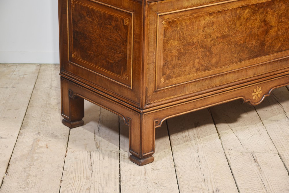 A two-section figured walnut press cupboard featuring twin panelled doors with crossbanded borders and bracket feet with a central star inlay. View IX