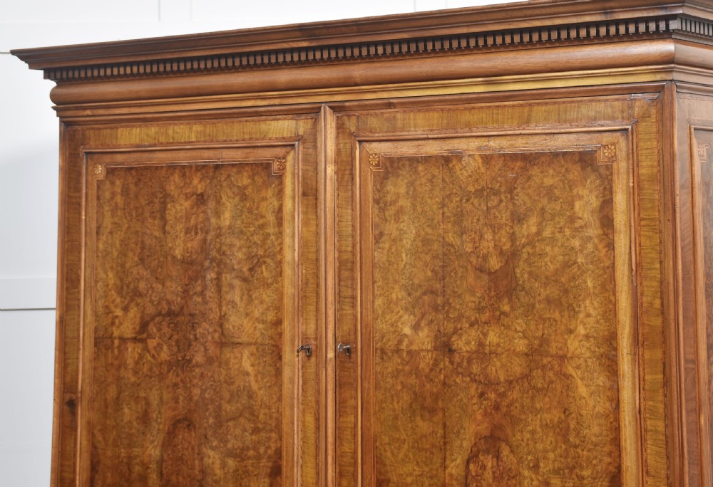 A two-section figured walnut press cupboard featuring twin panelled doors with crossbanded borders and bracket feet with a central star inlay. View XIII