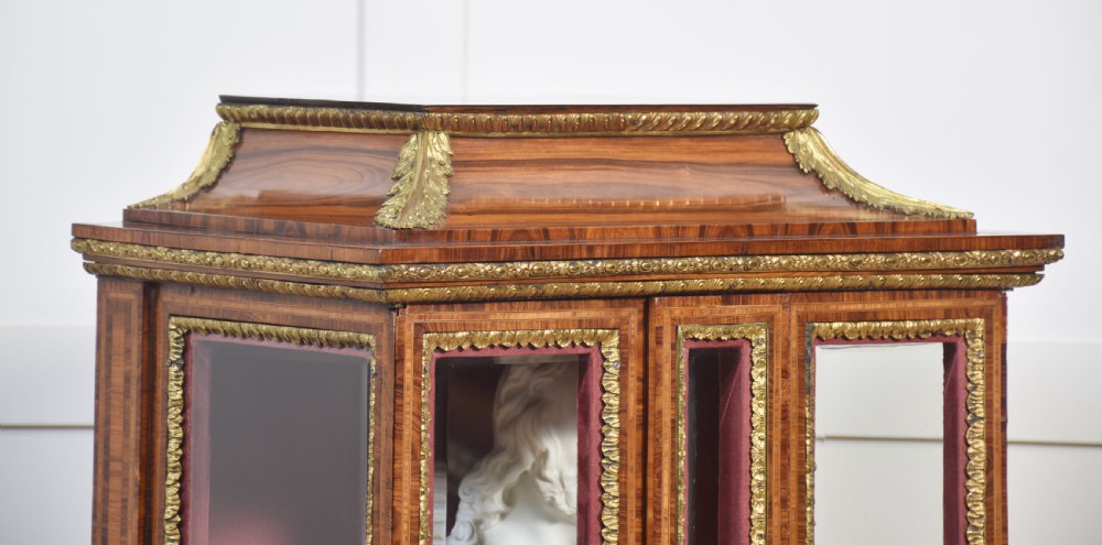An antique kingwood glazed display cabinet elevated on cabriole legs with decorative gilt bronze mounts and a burgundy fabric interior. View VII