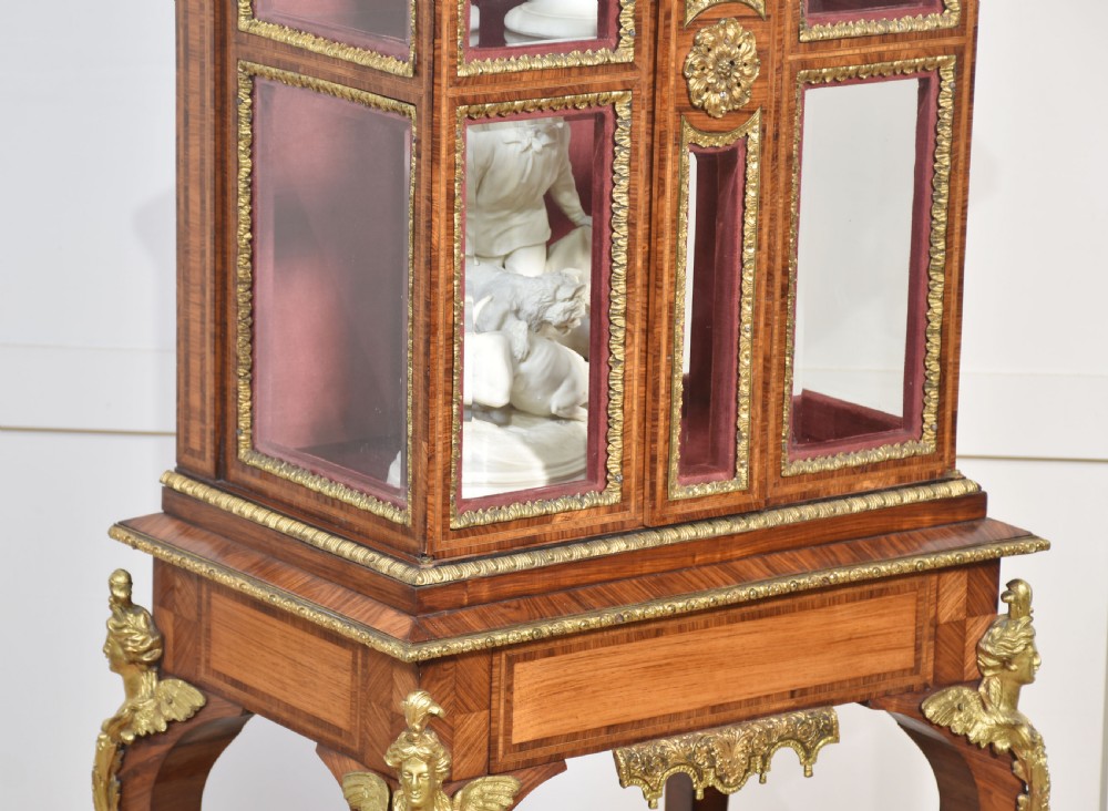 An antique kingwood glazed display cabinet elevated on cabriole legs with decorative gilt bronze mounts and a burgundy fabric interior. View VIII