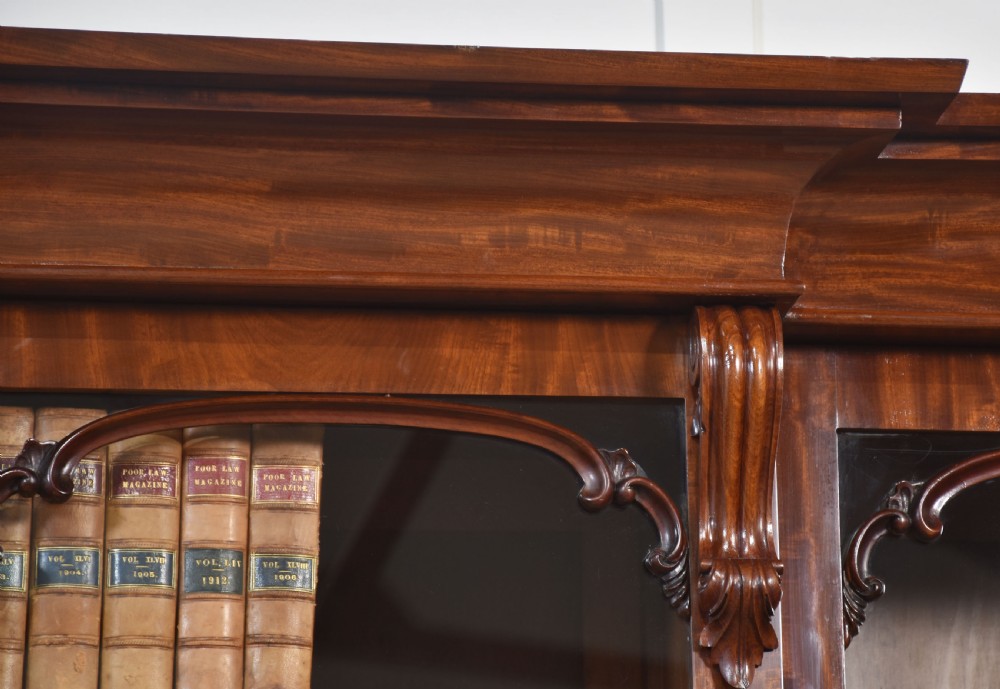 A 19th-century mahogany breakfront bookcase featuring glazed upper doors with adjustable shelves above a base with flame mahogany panelled doors. View II