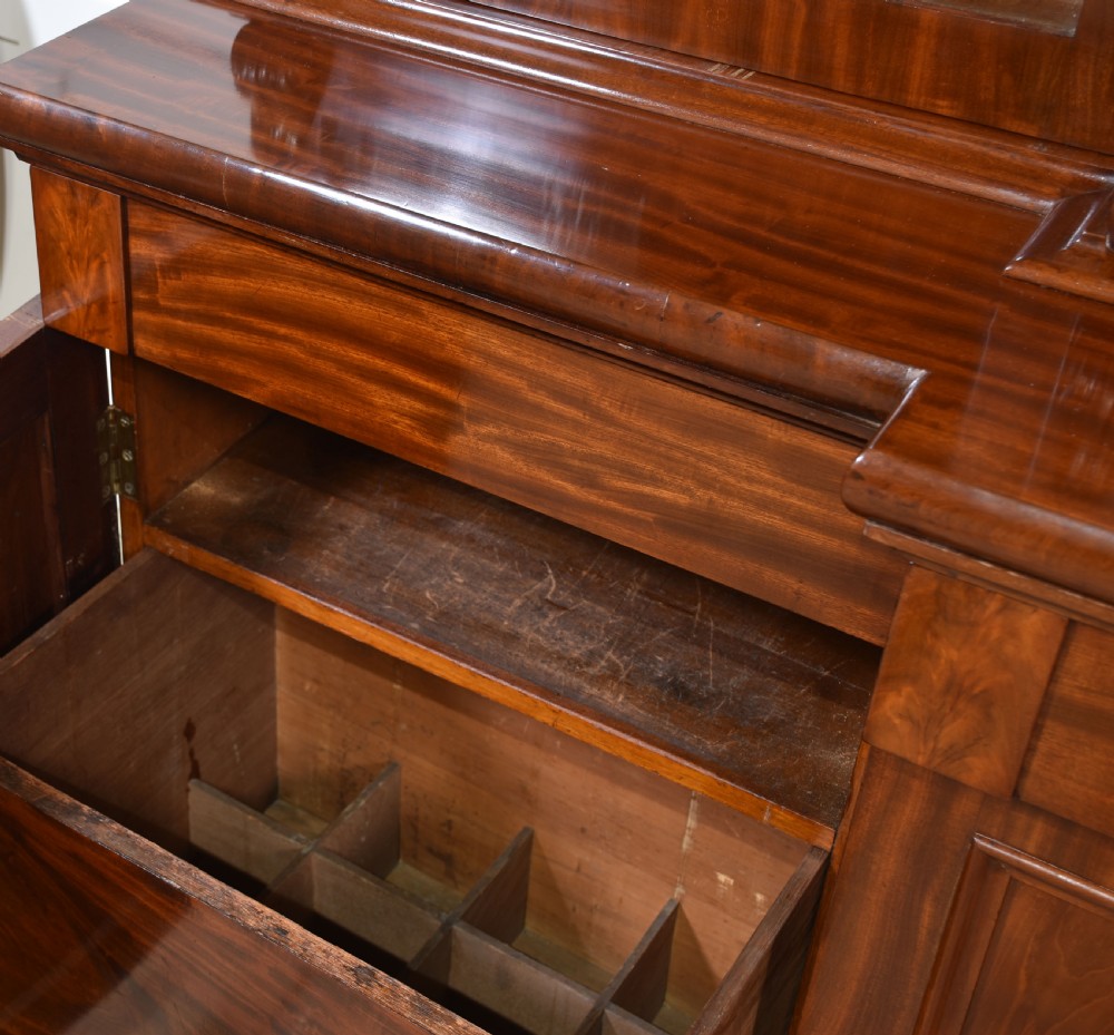 A 19th-century mahogany breakfront bookcase featuring glazed upper doors with adjustable shelves above a base with flame mahogany panelled doors. View V