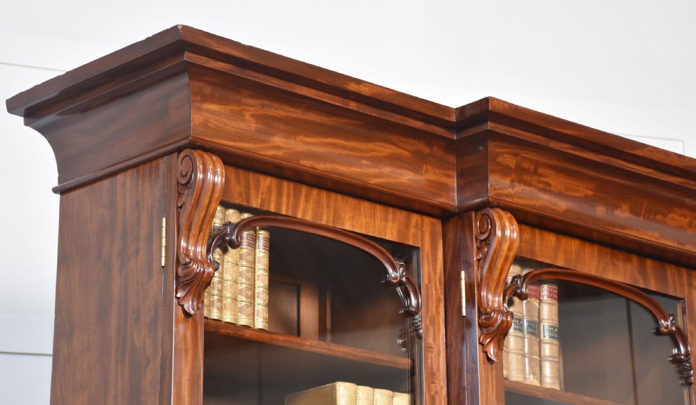 A 19th-century mahogany breakfront bookcase featuring glazed upper doors with adjustable shelves above a base with flame mahogany panelled doors. View VII