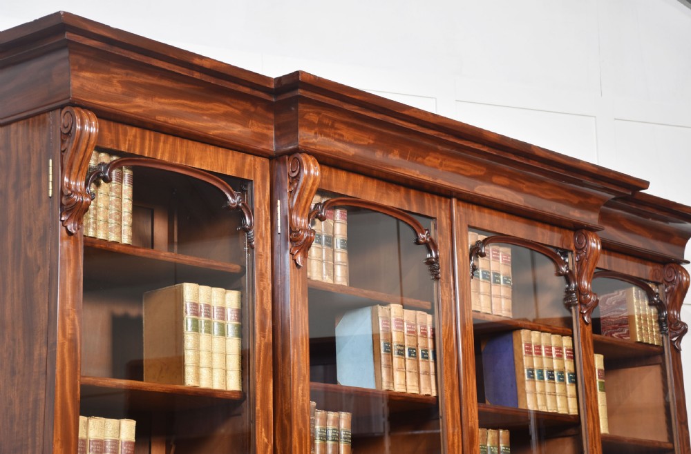 A 19th-century mahogany breakfront bookcase featuring glazed upper doors with adjustable shelves above a base with flame mahogany panelled doors. View VIII