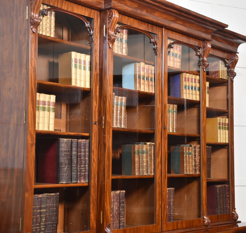 A 19th-century mahogany breakfront bookcase featuring glazed upper doors with adjustable shelves above a base with flame mahogany panelled doors. View IX