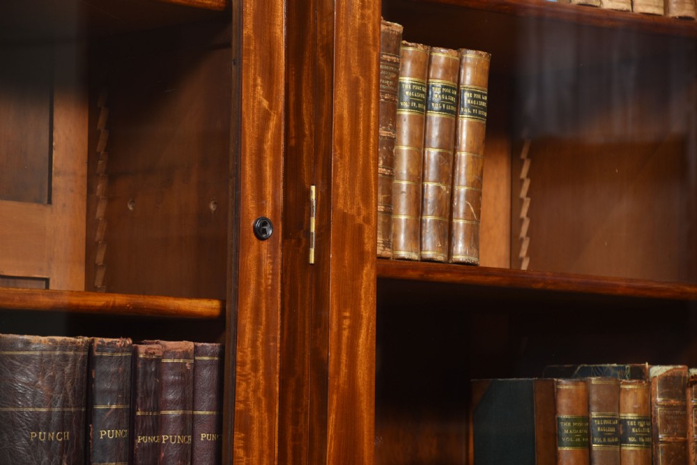 A 19th-century mahogany breakfront bookcase featuring glazed upper doors with adjustable shelves above a base with flame mahogany panelled doors. View XII