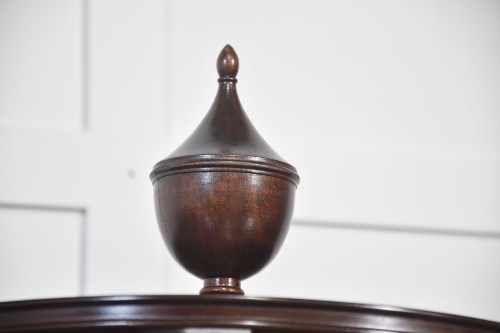A four-tiered mahogany revolving bookcase featuring a top finial, graduated open circular shelves, and a pedestal tripod base on brass castors. View XII