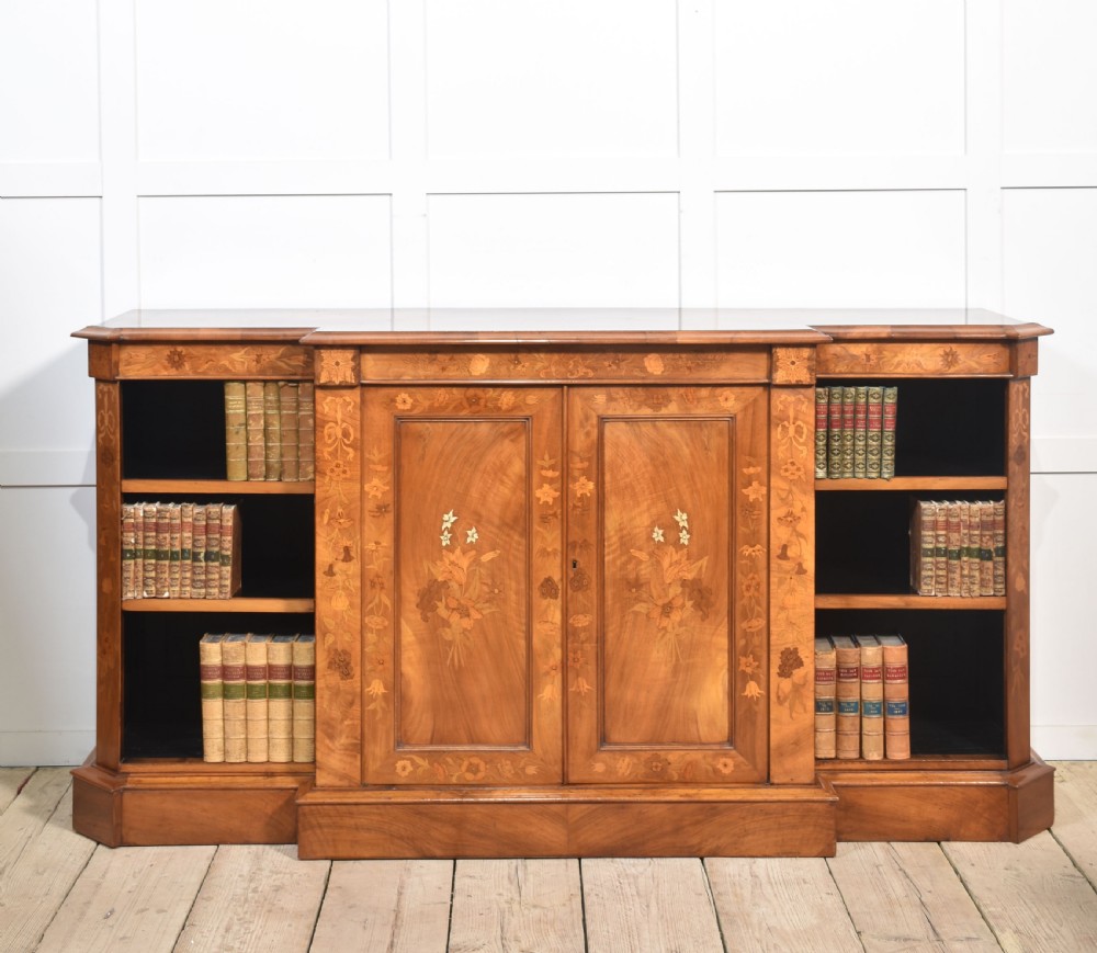 A low antique walnut breakfront bookcase featuring floral marquetry inlay across the central cupboard doors and top frieze, flanked by open adjustable shelves. View II