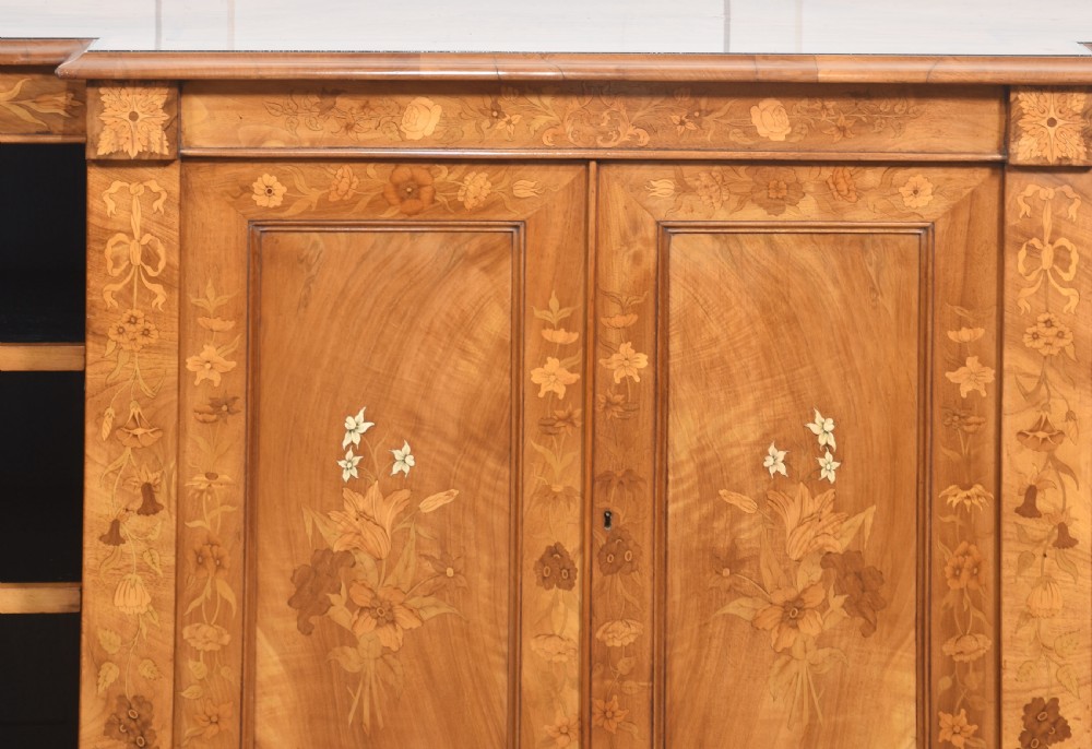 A low antique walnut breakfront bookcase featuring floral marquetry inlay across the central cupboard doors and top frieze, flanked by open adjustable shelves. View XII