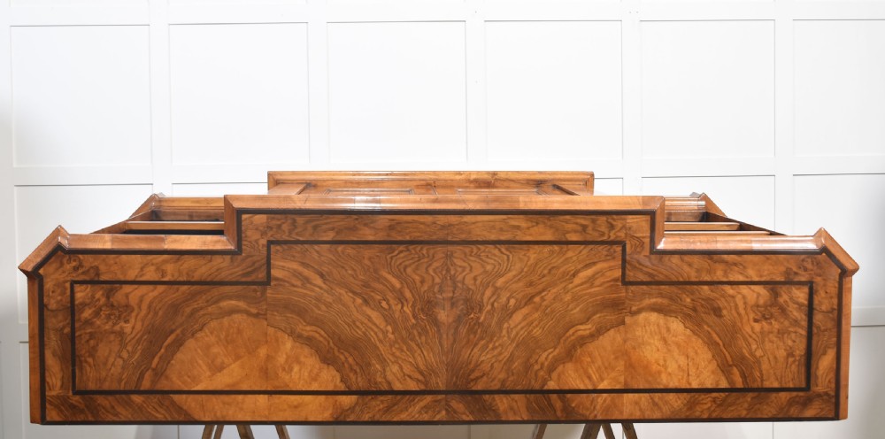 A low antique walnut breakfront bookcase featuring floral marquetry inlay across the central cupboard doors and top frieze, flanked by open adjustable shelves. View XVII