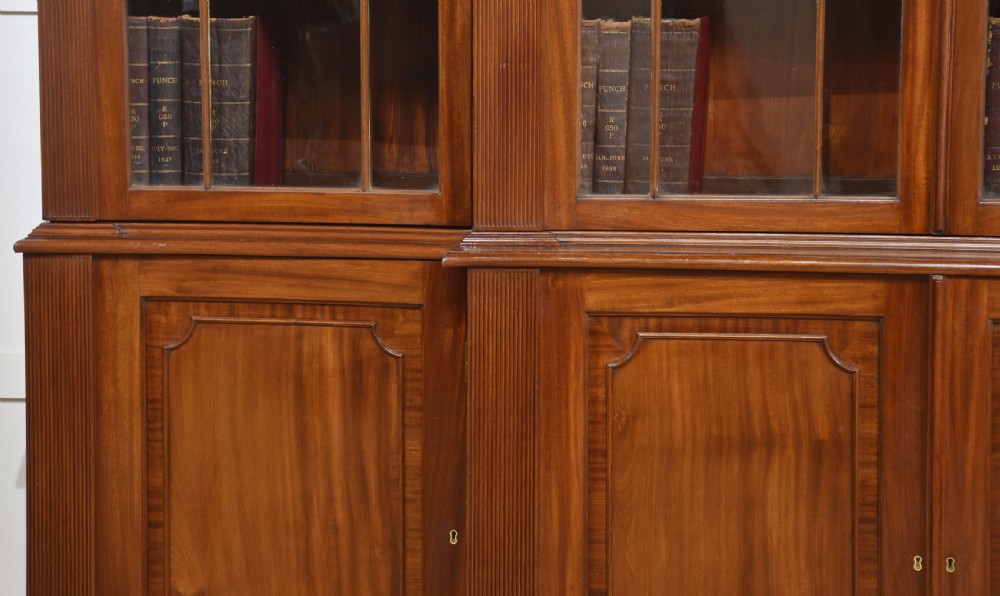 A large Regency mahogany breakfront library bookcase featuring four astragal glazed doors with Gothic arch detailing over four panelled cupboard bases. View III