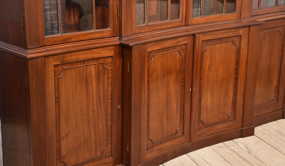 A large Regency mahogany breakfront library bookcase featuring four astragal glazed doors with Gothic arch detailing over four panelled cupboard bases. View XIV