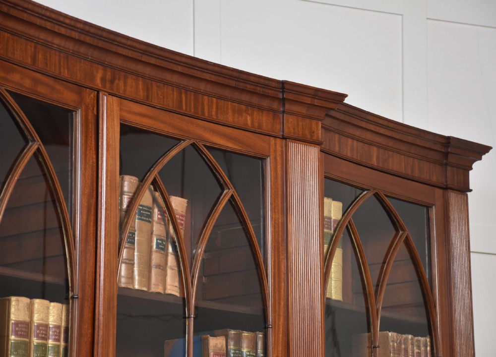 A large Regency mahogany breakfront library bookcase featuring four astragal glazed doors with Gothic arch detailing over four panelled cupboard bases. View XV