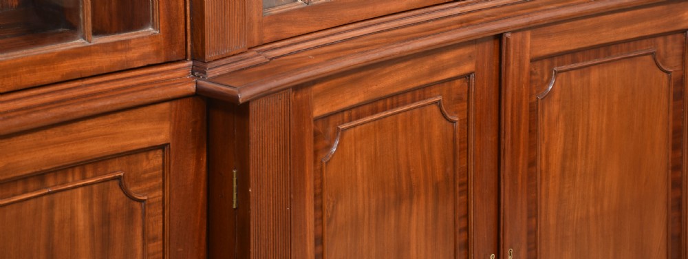 A large Regency mahogany breakfront library bookcase featuring four astragal glazed doors with Gothic arch detailing over four panelled cupboard bases. View XVI