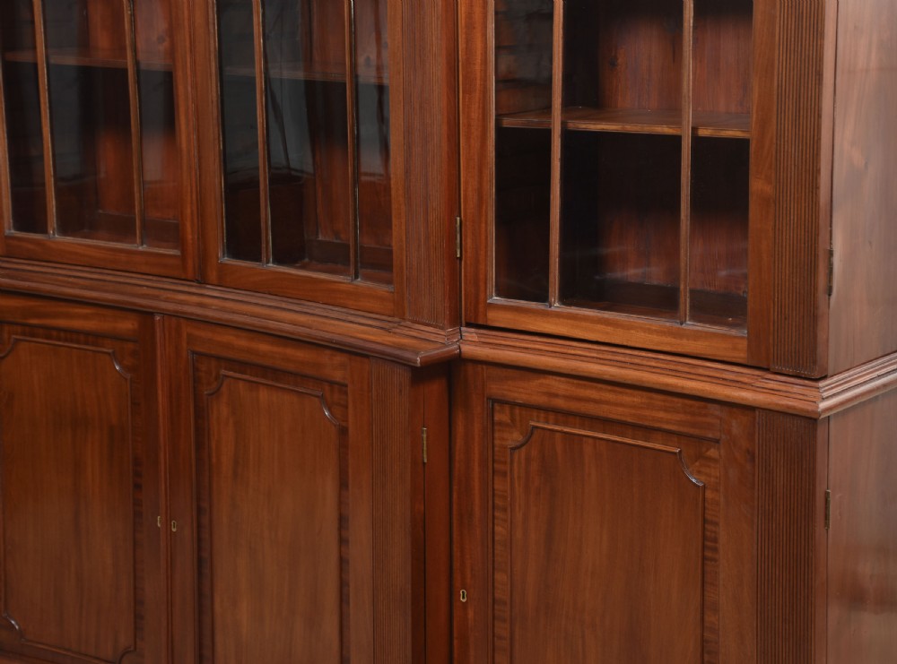 A large Regency mahogany breakfront library bookcase featuring four astragal glazed doors with Gothic arch detailing over four panelled cupboard bases. View XIX