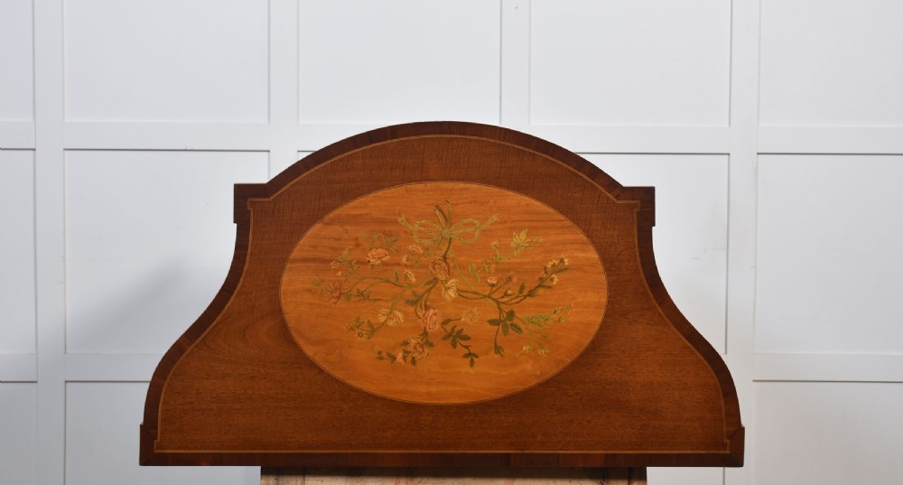 A near pair of bow-fronted mahogany chests of drawers featuring detailed floral marquetry inlay, brass handles, and slender tapered legs. View XIII