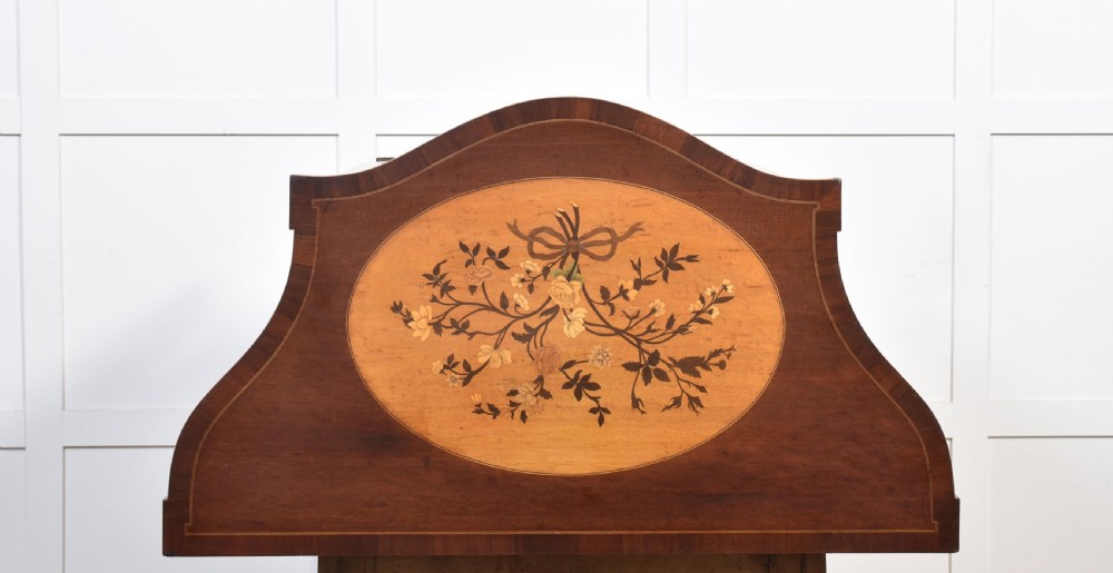 A near pair of bow-fronted mahogany chests of drawers featuring detailed floral marquetry inlay, brass handles, and slender tapered legs. View XIV