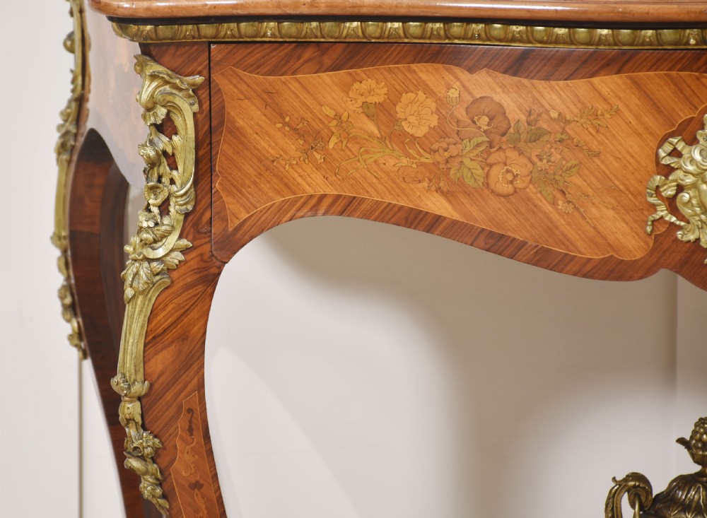 A Louis Philippe tulipwood dressing table featuring floral marquetry inlay, gilt bronze ormolu mounts, a shaped mirror with attached sconces, and cabriole legs. View V