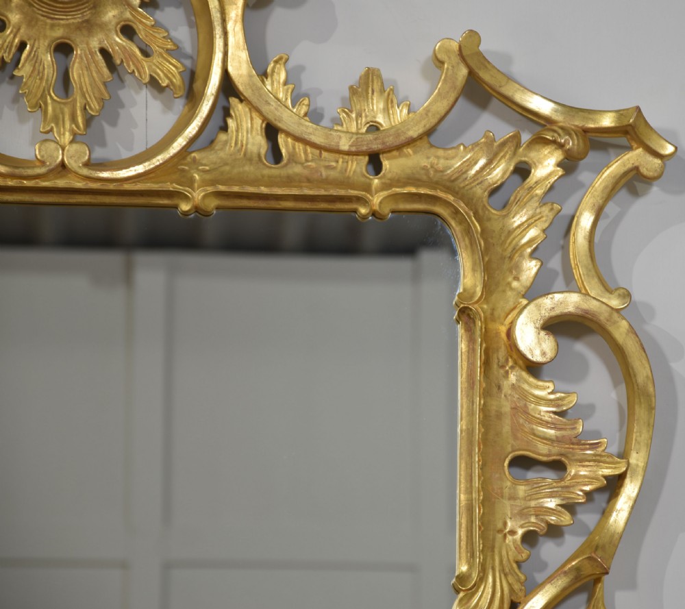 An ornate rectangular Rococo revival wall mirror featuring an elaborate carved giltwood frame with a tall cresting motif, acanthus leaf detailing, and pierced scrollwork. View III