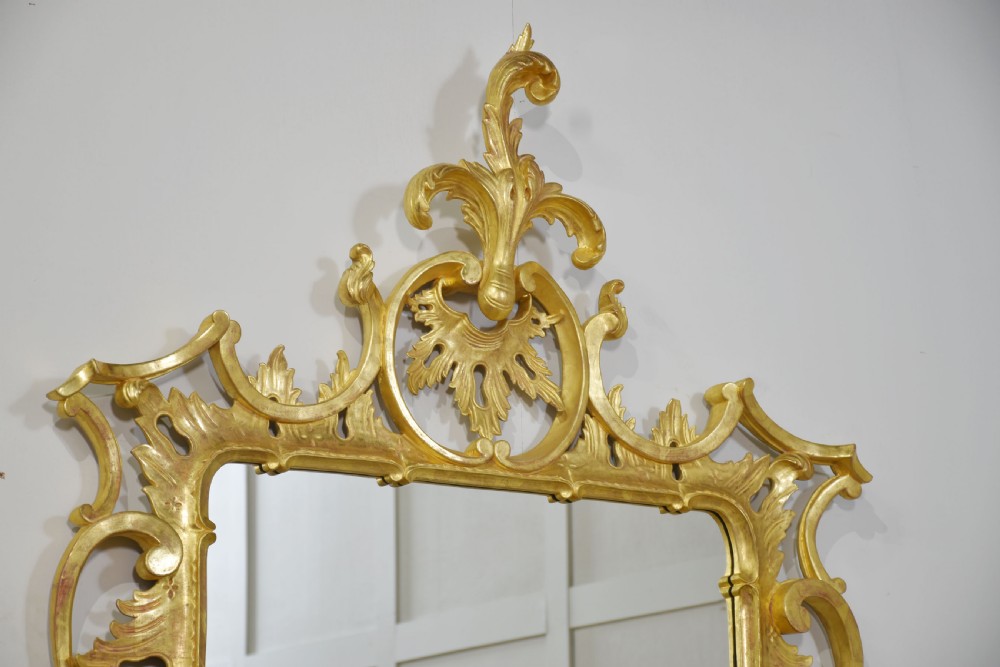 An ornate rectangular Rococo revival wall mirror featuring an elaborate carved giltwood frame with a tall cresting motif, acanthus leaf detailing, and pierced scrollwork. View XII