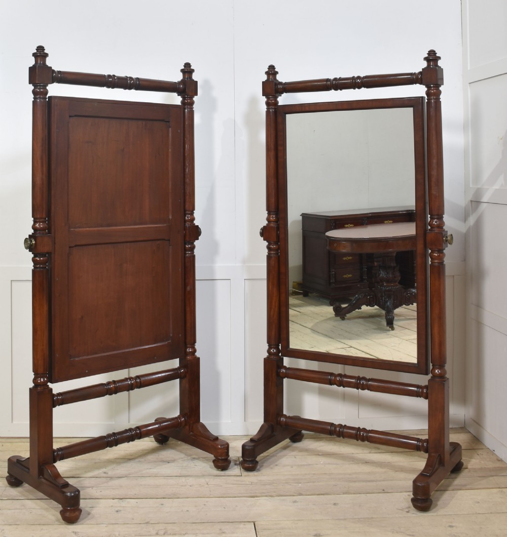 A pair of antique mahogany cheval mirrors featuring rectangular tilting glass plates, turned vertical supports, horizontal stretchers, and brass hardware. View VII