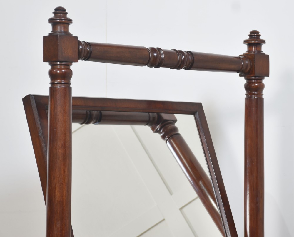 A pair of antique mahogany cheval mirrors featuring rectangular tilting glass plates, turned vertical supports, horizontal stretchers, and brass hardware. View XI