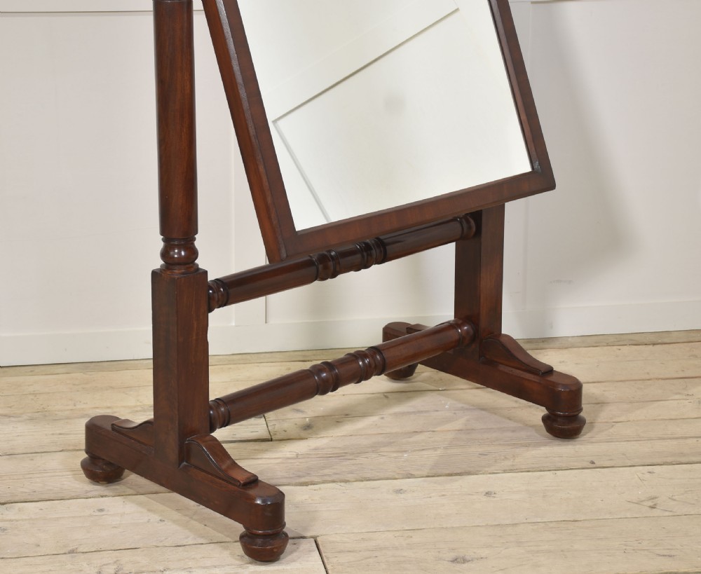 A pair of antique mahogany cheval mirrors featuring rectangular tilting glass plates, turned vertical supports, horizontal stretchers, and brass hardware. View XII