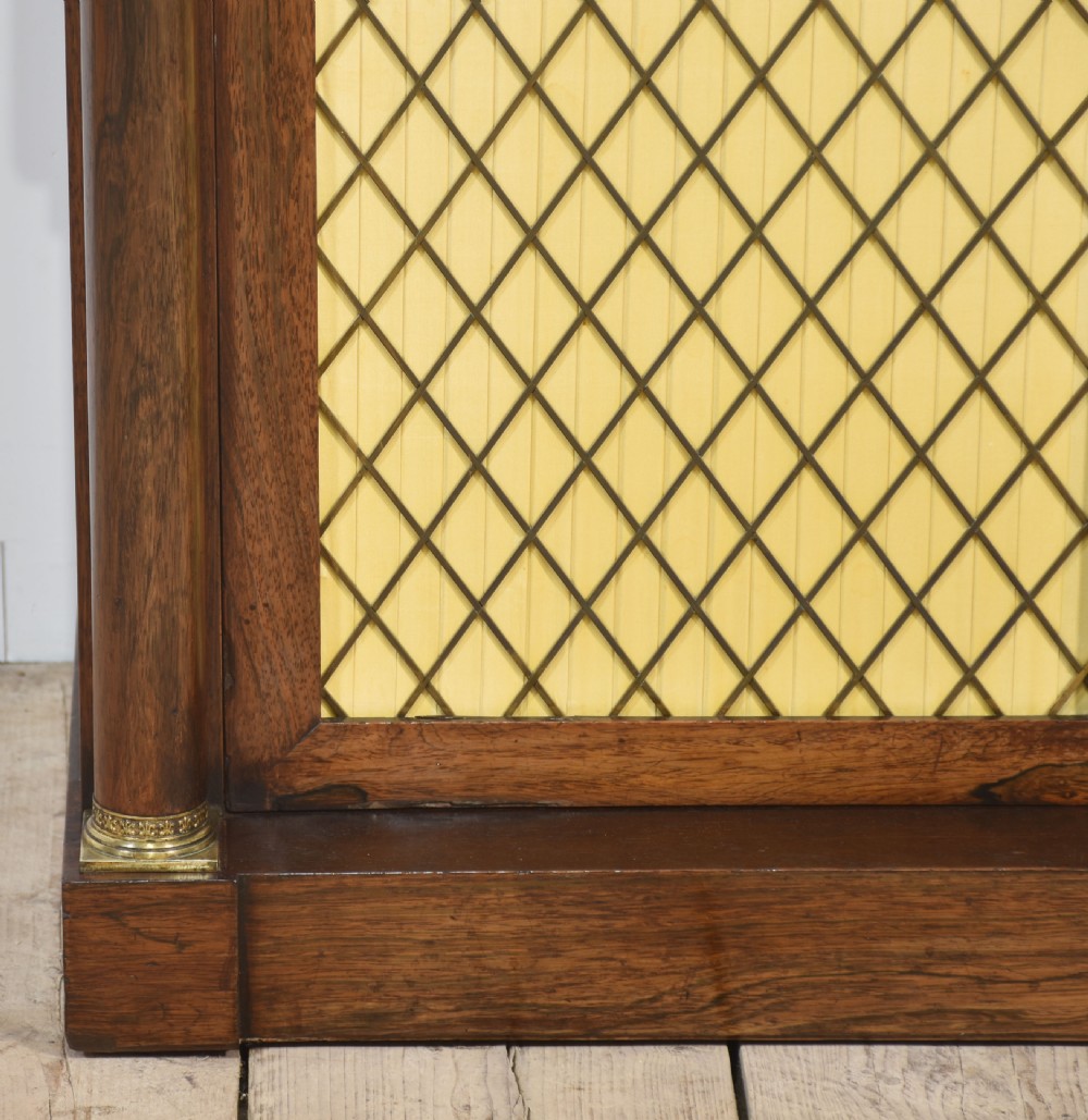 A nineteenth-century dark rosewood two-door cabinet featuring a white marble top, brass grille doors with pleated fabric lining, and columnar side supports. View VI