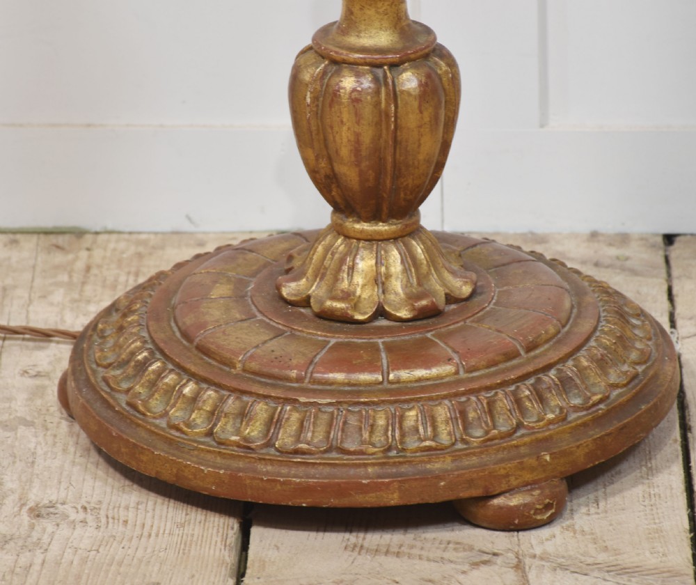 A carved giltwood standard lamp featuring a barley twist shaft, turned circular base, and a pale blue patterned shade with cream fringe. View V