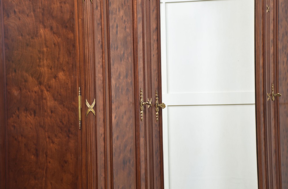 A 19th-century French Louis XVI mahogany wardrobe featuring a central arched mirrored door flanked by twin panelled side doors with gilt bronze mounts. View XI