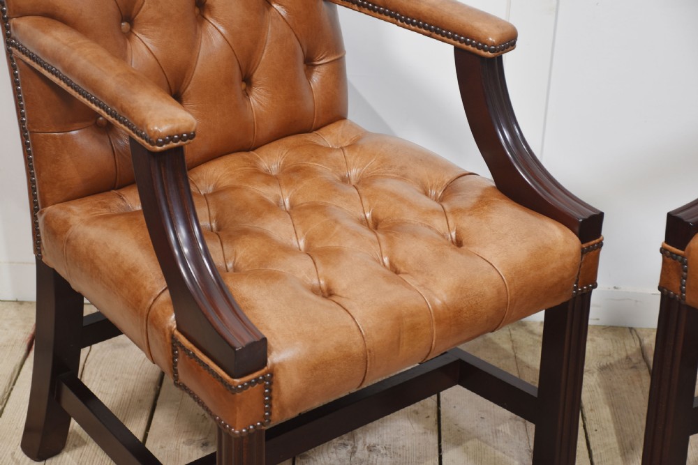 A pair of Georgian style tan leather Gainsborough library chairs featuring deep buttoned upholstery, brass studding, and dark mahogany frames. View III