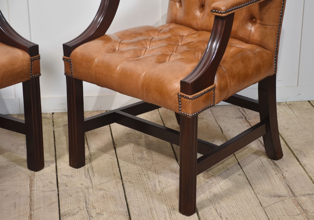 A pair of Georgian style tan leather Gainsborough library chairs featuring deep buttoned upholstery, brass studding, and dark mahogany frames. View VII