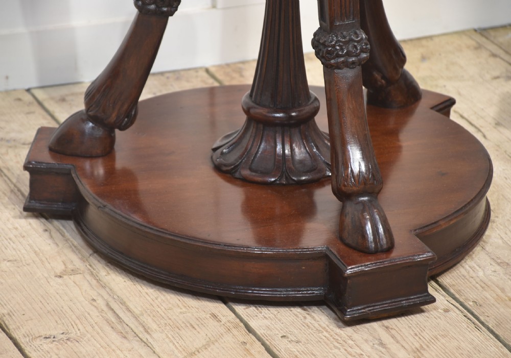 A pair of tall carved mahogany torchere plant stands featuring curved legs, carved foliage details, lower stretchers with finials, and circular bases. View VIII