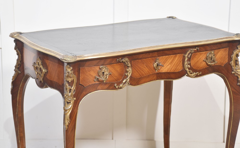 A nineteenth-century French bureau plat desk with cabriole legs, a leather writing surface, and ornate gilt bronze corner mounts. View II