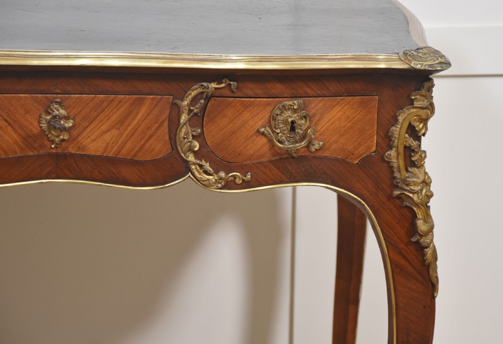 A nineteenth-century French bureau plat desk with cabriole legs, a leather writing surface, and ornate gilt bronze corner mounts. View VIII